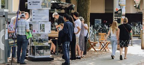Menschen erkundigen sich an einer Mobilitätsstation