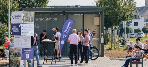 Menschen erkundigen sich an einer Mobilitätsstation