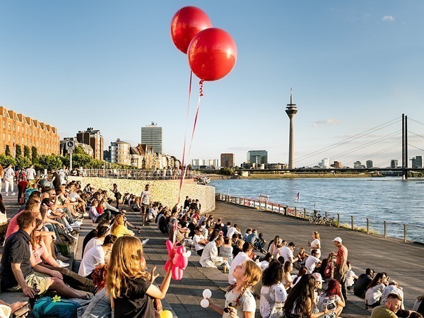 Ein Mädchen hält zwei Ballons und steht am Burgplatz